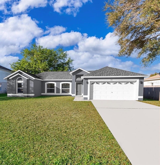 ranch-style house featuring driveway, an attached garage, a front yard, and stucco siding