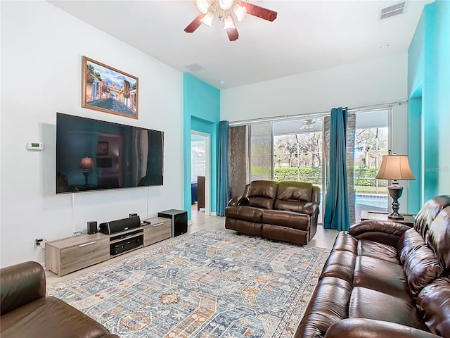 living area featuring ceiling fan and visible vents