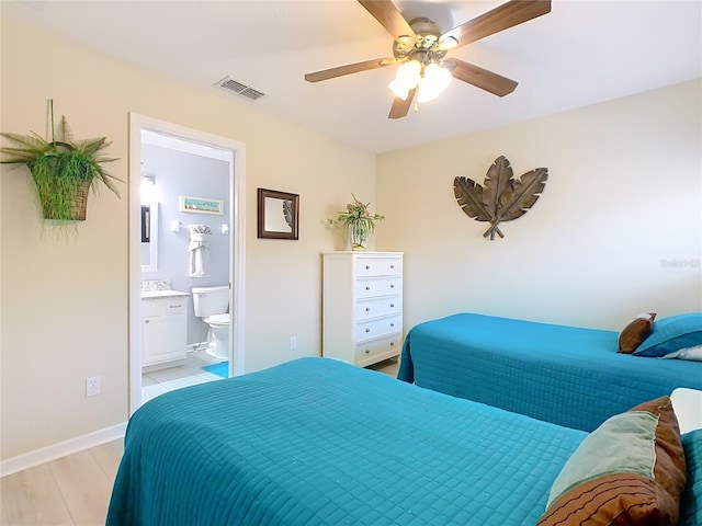 bedroom with visible vents, light wood-style floors, a ceiling fan, ensuite bath, and baseboards