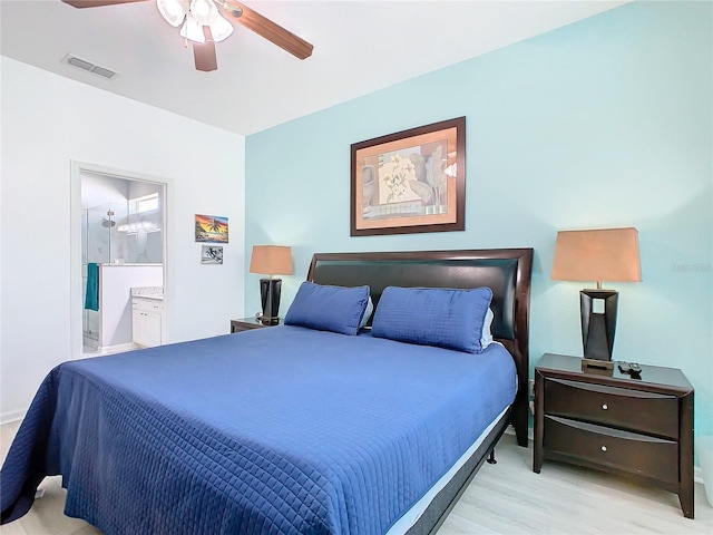 bedroom with ceiling fan, light wood finished floors, ensuite bath, and visible vents