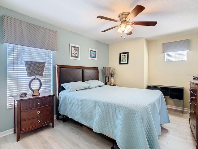 bedroom featuring a ceiling fan, baseboards, and light wood finished floors