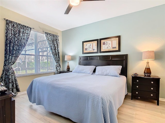 bedroom featuring light wood-style flooring, baseboards, and ceiling fan