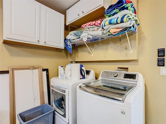 washroom with cabinet space and washer and clothes dryer