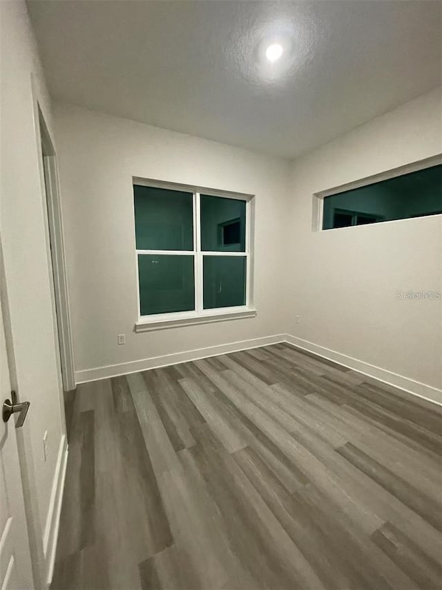 spare room with a textured ceiling and hardwood / wood-style floors