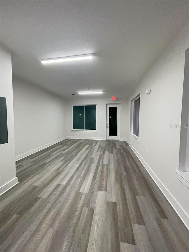 empty room with hardwood / wood-style flooring and electric panel