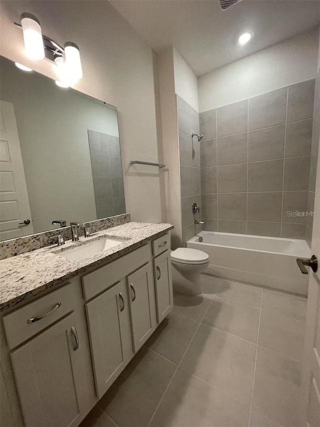 full bathroom featuring tiled shower / bath combo, vanity, toilet, and tile patterned floors