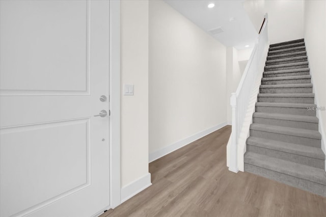 stairs featuring hardwood / wood-style flooring