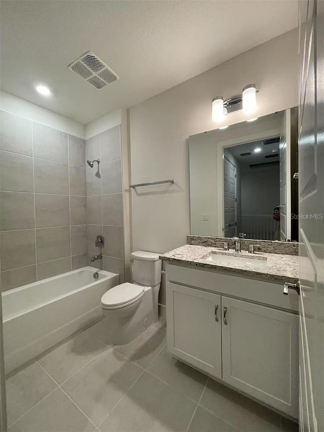 full bathroom with tiled shower / bath combo, vanity, toilet, and tile patterned floors