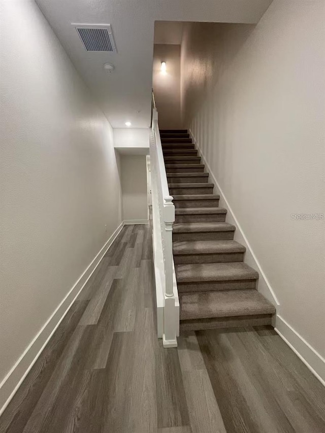 stairs featuring hardwood / wood-style floors