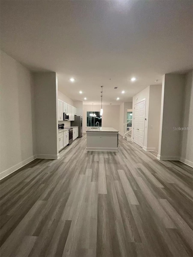 unfurnished living room with sink and hardwood / wood-style flooring