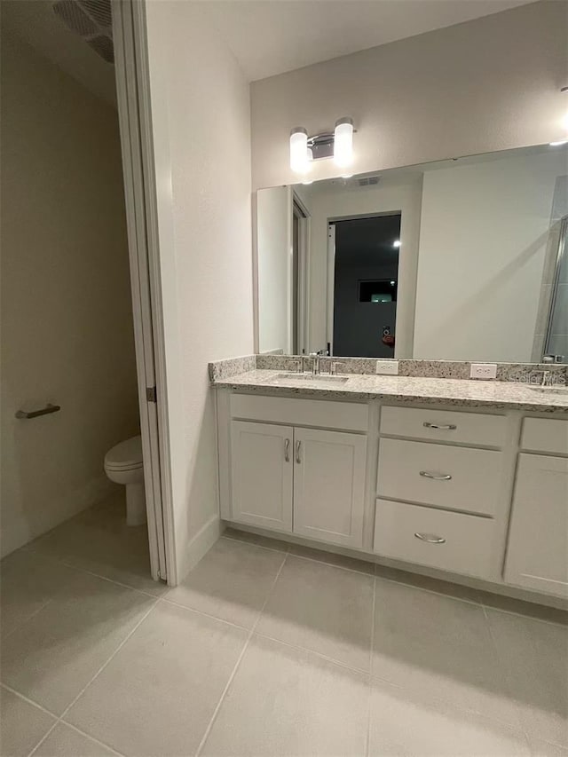 bathroom featuring tile patterned floors, vanity, and toilet