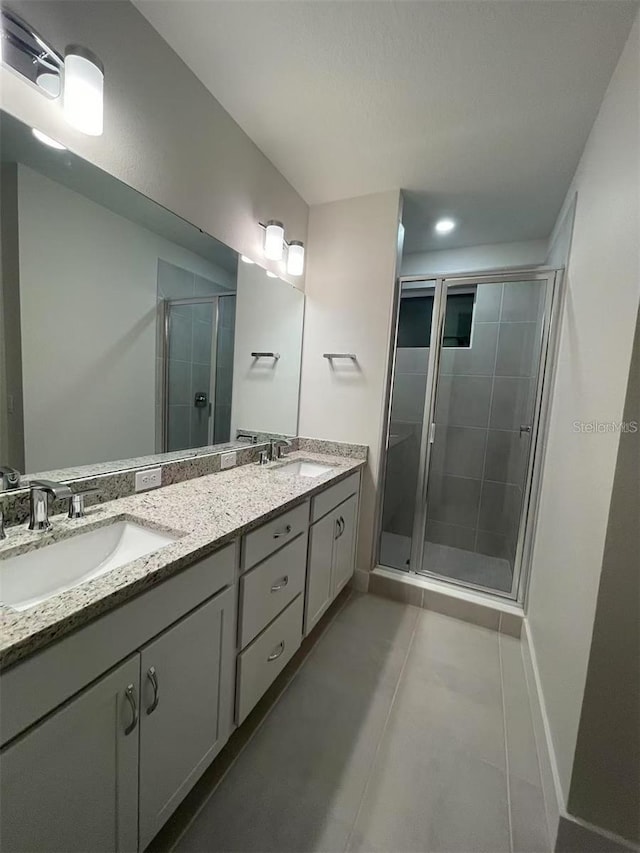 bathroom featuring vanity, a shower with shower door, and tile patterned floors