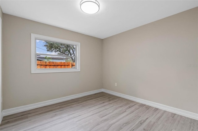 spare room featuring light wood-style floors and baseboards