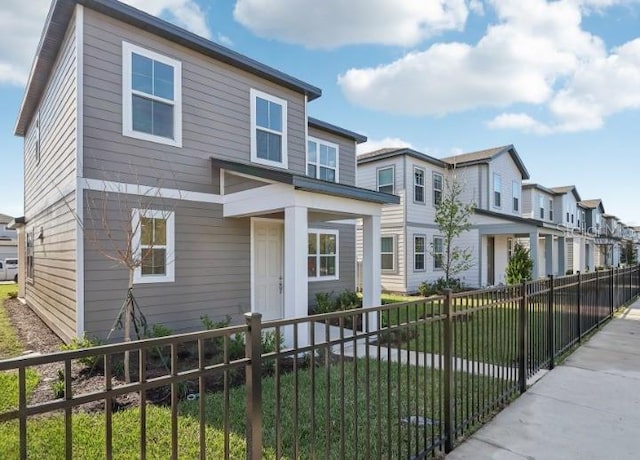 view of front of property featuring a fenced front yard, a residential view, and a front lawn