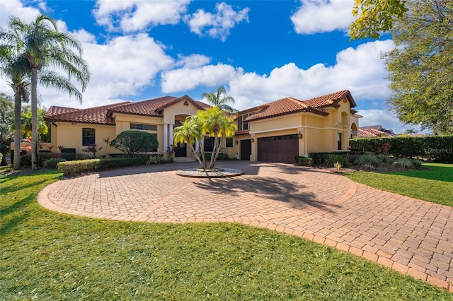 mediterranean / spanish house with a garage and a front yard