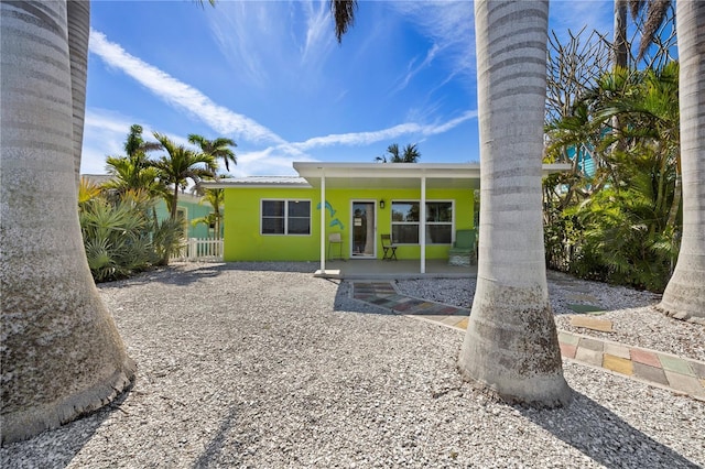 rear view of property with fence and stucco siding