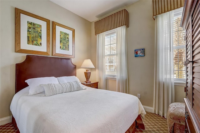 bedroom with carpet, multiple windows, and baseboards