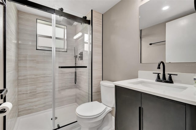 bathroom with vanity, an enclosed shower, and toilet