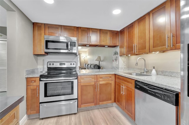 kitchen featuring appliances with stainless steel finishes, sink, and light stone counters