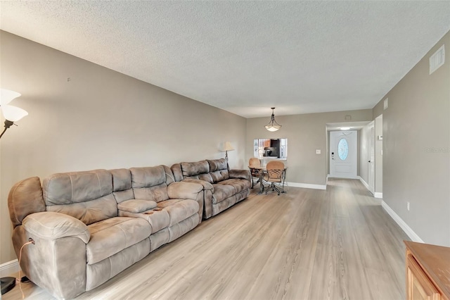 living room with light hardwood / wood-style flooring and a textured ceiling