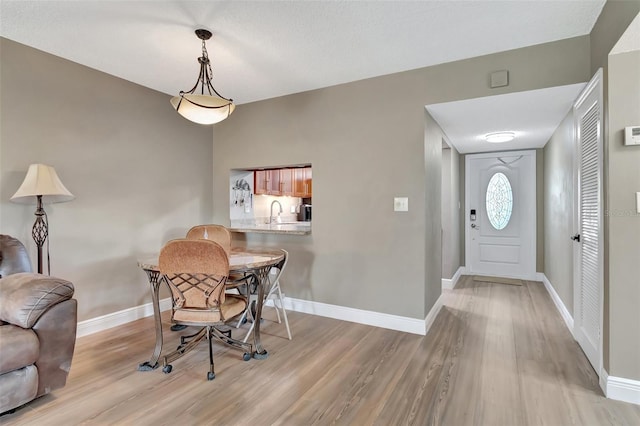 dining room featuring sink and light wood-type flooring