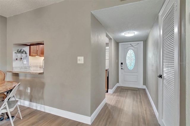 interior space with a textured ceiling and light hardwood / wood-style floors