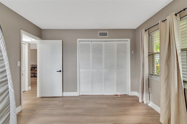 unfurnished bedroom featuring light hardwood / wood-style floors and a closet