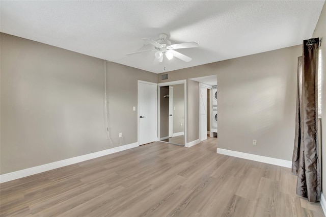 unfurnished room featuring a textured ceiling, ceiling fan, and light hardwood / wood-style flooring