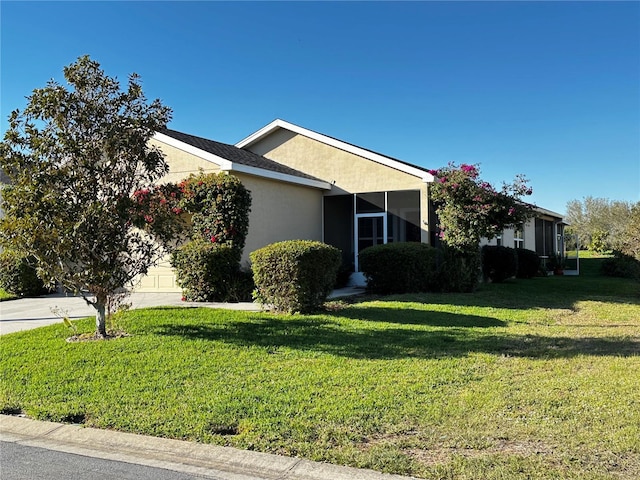 view of property exterior featuring a yard, driveway, an attached garage, and stucco siding