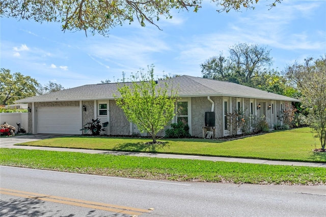 single story home featuring driveway, a garage, a shingled roof, stone siding, and a front yard