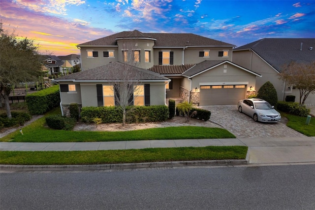 view of front of house with a garage, decorative driveway, and stucco siding