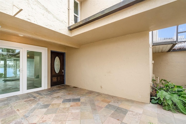 property entrance featuring a patio and stucco siding