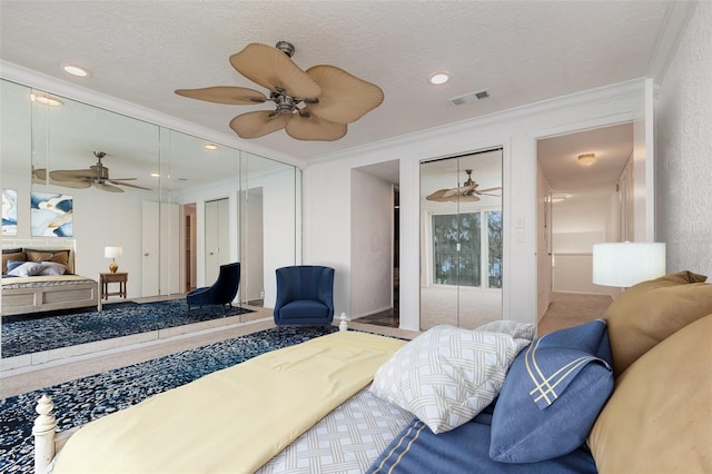 bedroom with visible vents, ornamental molding, ceiling fan, and a textured ceiling