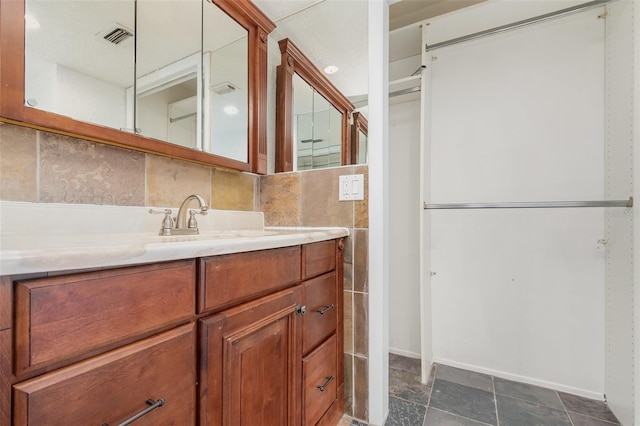 bathroom featuring tasteful backsplash, visible vents, tile walls, and vanity