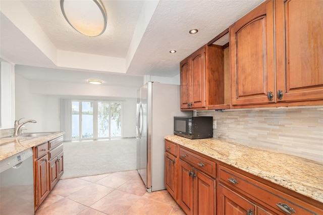 kitchen featuring decorative backsplash, dishwasher, brown cabinets, black microwave, and a sink