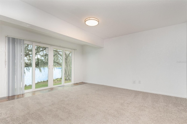 carpeted empty room with french doors and baseboards