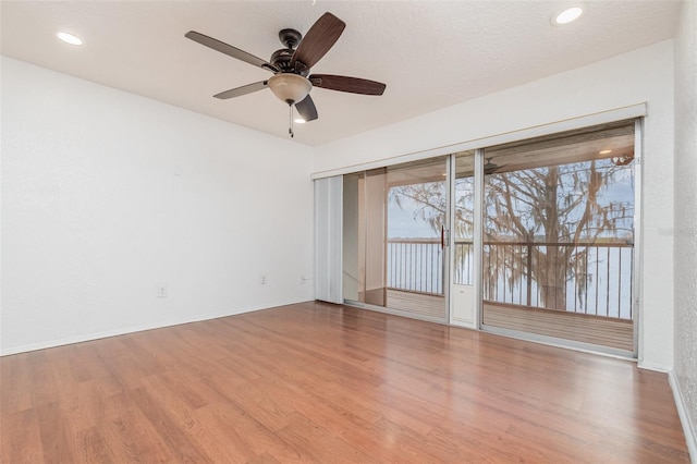 empty room with recessed lighting, wood finished floors, and baseboards