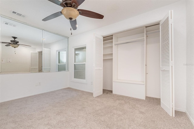 unfurnished bedroom featuring a closet, visible vents, ceiling fan, and carpet flooring