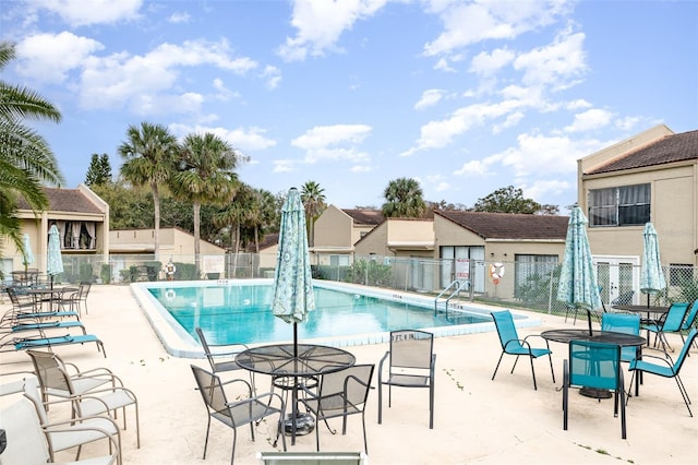 community pool featuring fence and a patio