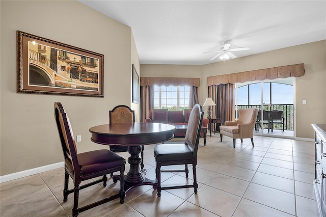 dining area with light tile patterned floors, ceiling fan, and baseboards