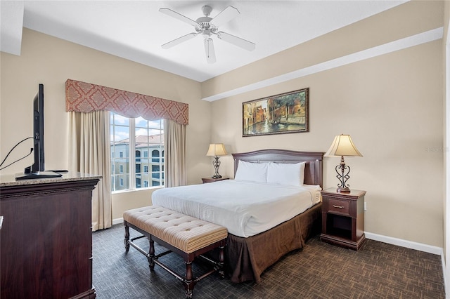 bedroom with baseboards, dark carpet, and a ceiling fan