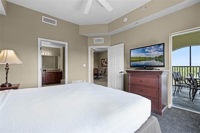 bedroom with visible vents, dark carpet, and ensuite bathroom