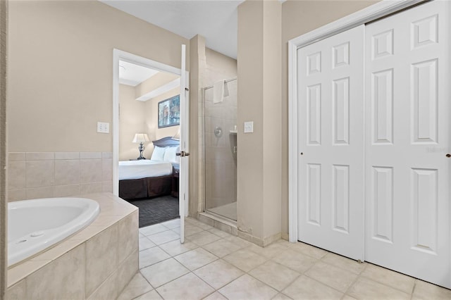 full bathroom with tile patterned floors, a shower stall, tiled bath, and ensuite bathroom