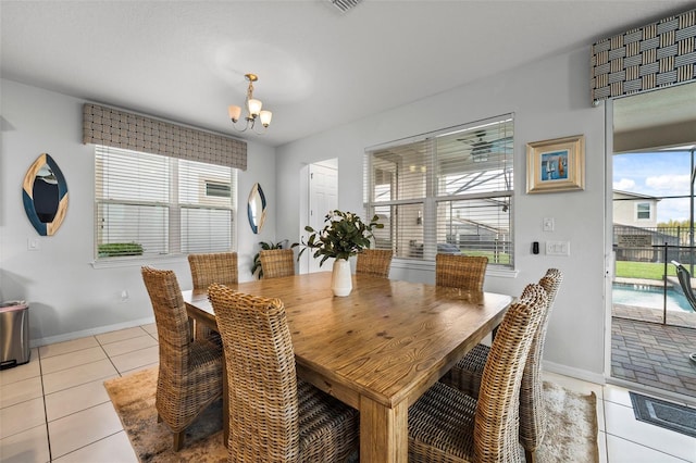 dining space featuring light tile patterned floors and a chandelier