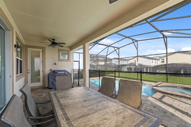 view of patio featuring ceiling fan, a grill, a pool with hot tub, and glass enclosure