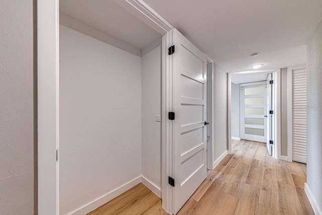 hallway with light wood-style flooring and baseboards