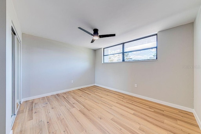 unfurnished room featuring light wood-style floors, baseboards, and a ceiling fan