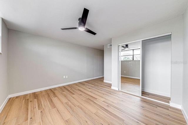 unfurnished bedroom with baseboards, a closet, visible vents, and light wood-style floors
