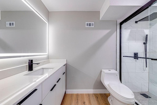 bathroom featuring toilet, visible vents, wood finished floors, and vanity