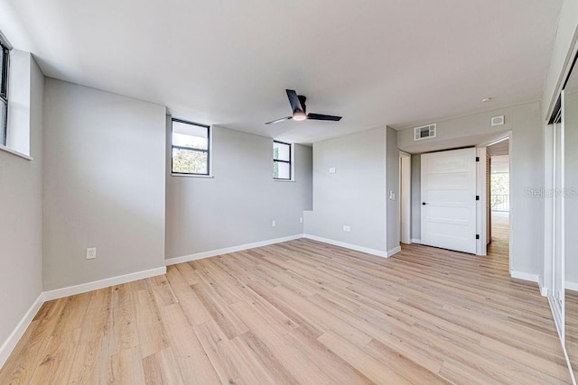 empty room featuring visible vents, ceiling fan, light wood-style flooring, and baseboards